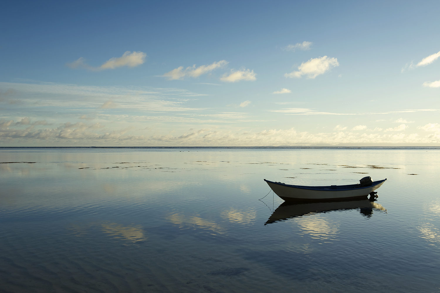 a small boat floating in still and empty waters