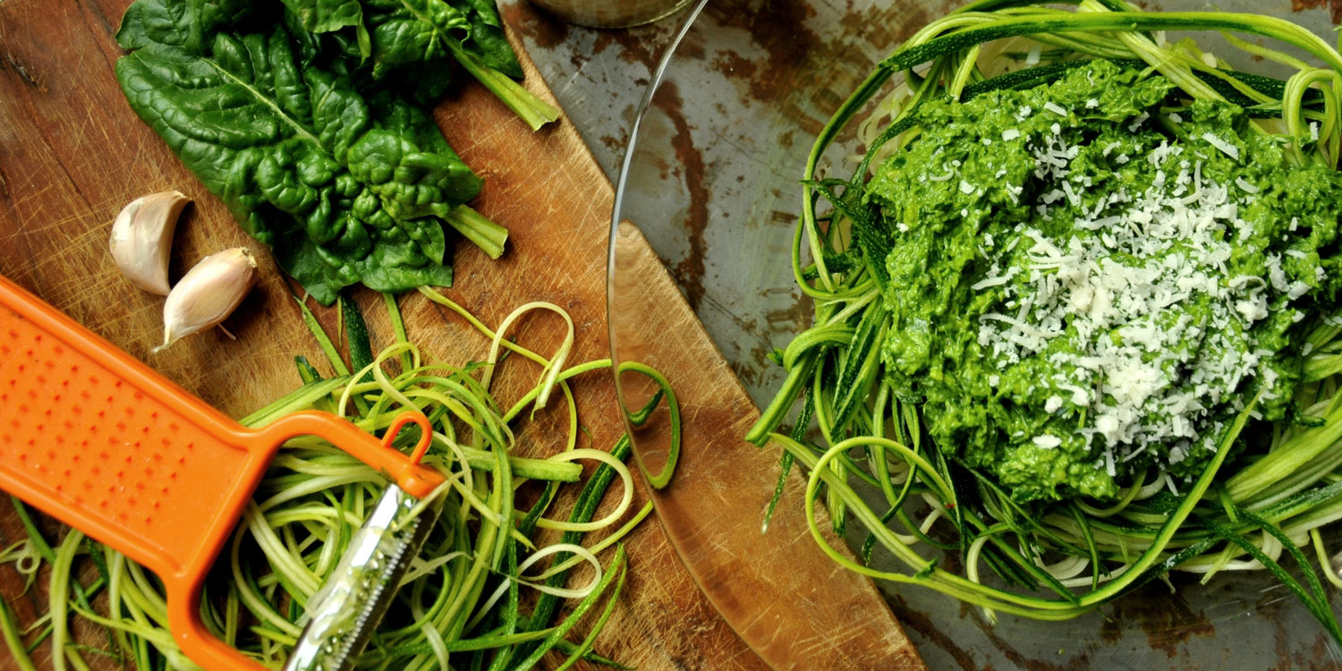 zucchini being shredded into noodles