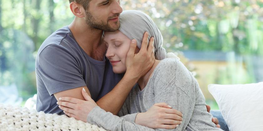 a woman with cancer being held by her partner