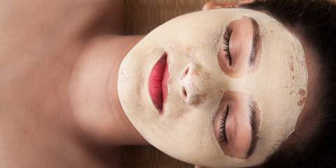An indian woman with closed eyes relaxing and having an Ayurvedic face mask
