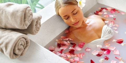 a woman taking a calming bath with milk and herbs