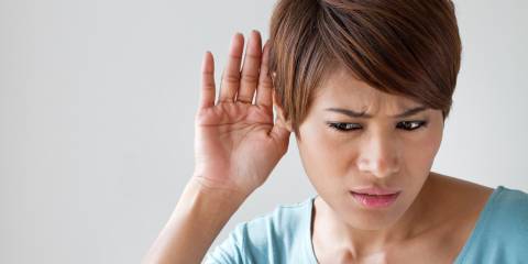a woman straining to hear what's being said to her