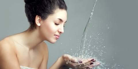 Woman with water pouring into her hands.