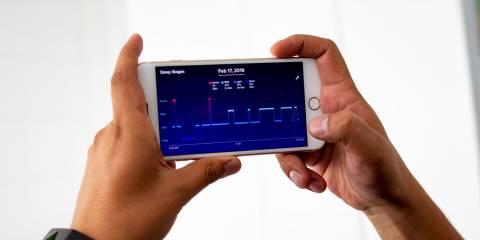 Man laying  monitoring his sleep night with app.