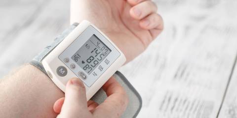 a man checking his blood pressure at home with electronics