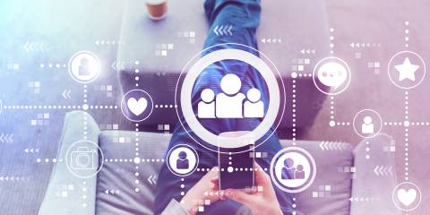 Man using a cell phone with social media icons illustrated above it.