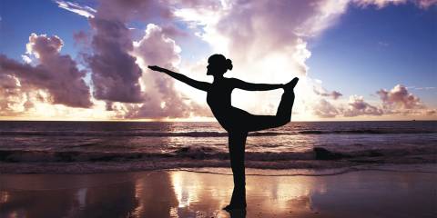 A woman doing yoga on the beach