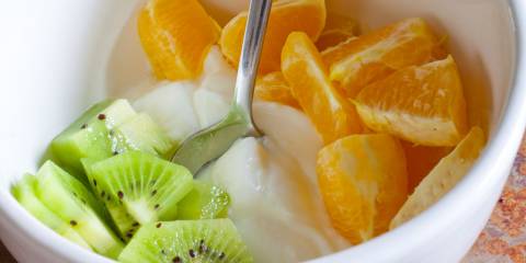 a bowl of yogurt with oranges and kiwi