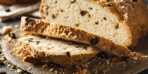 a freshly baked and sliced loaf of soda bread with raisins