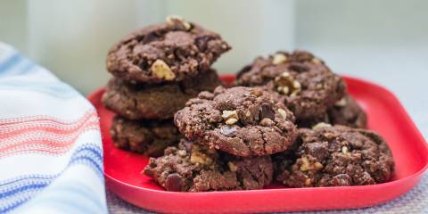 A plate of chocolate chip oatmeal cookies and two tall glasses of milk