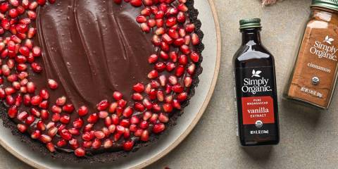 a no-bake tart covered in ganache and pomegranate arils