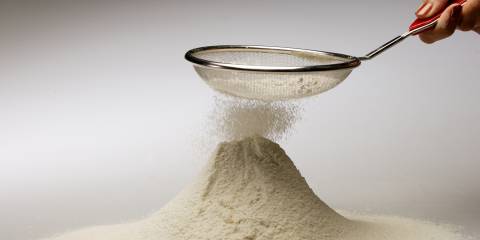 alternative flour falling from a sifter into a pile