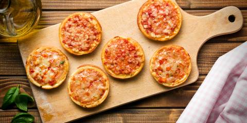 mini pizzas on a cutting board