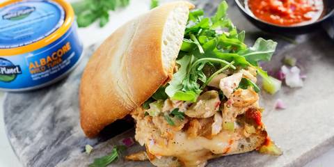 a tuna sandwich with cheese and spicy sauce