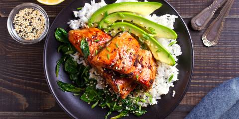 pan-seared salmon with sesame seeds on a bed of rice and greens
