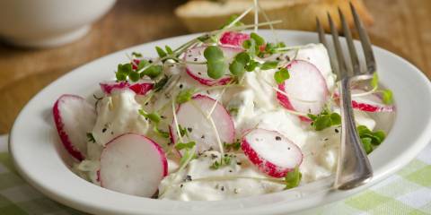 a bowl of potato salad with sliced radish