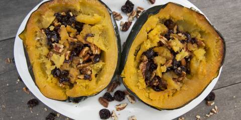 A plate of acorn squash stuffed with berries and pecans