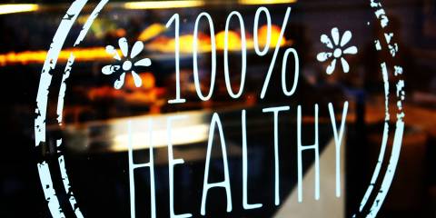a restaurant with a sticker in the window that says "100% healthy"