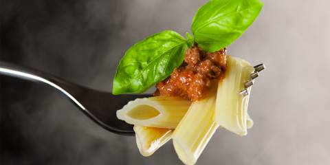 Perfectly cooked penne on a fork with rolling steam